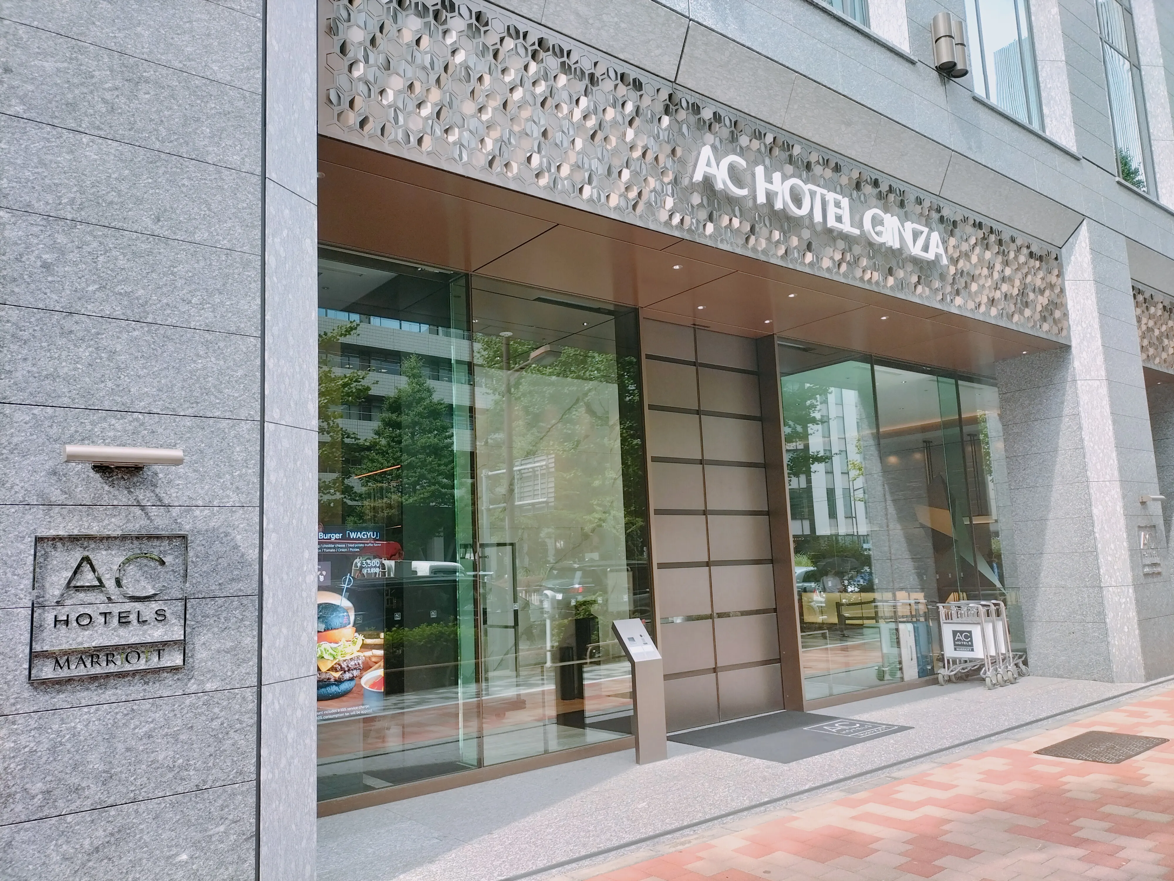 AC HOTEL GINZAの名称サインとガラス扉が見えるACホテル東京銀座のエントランス