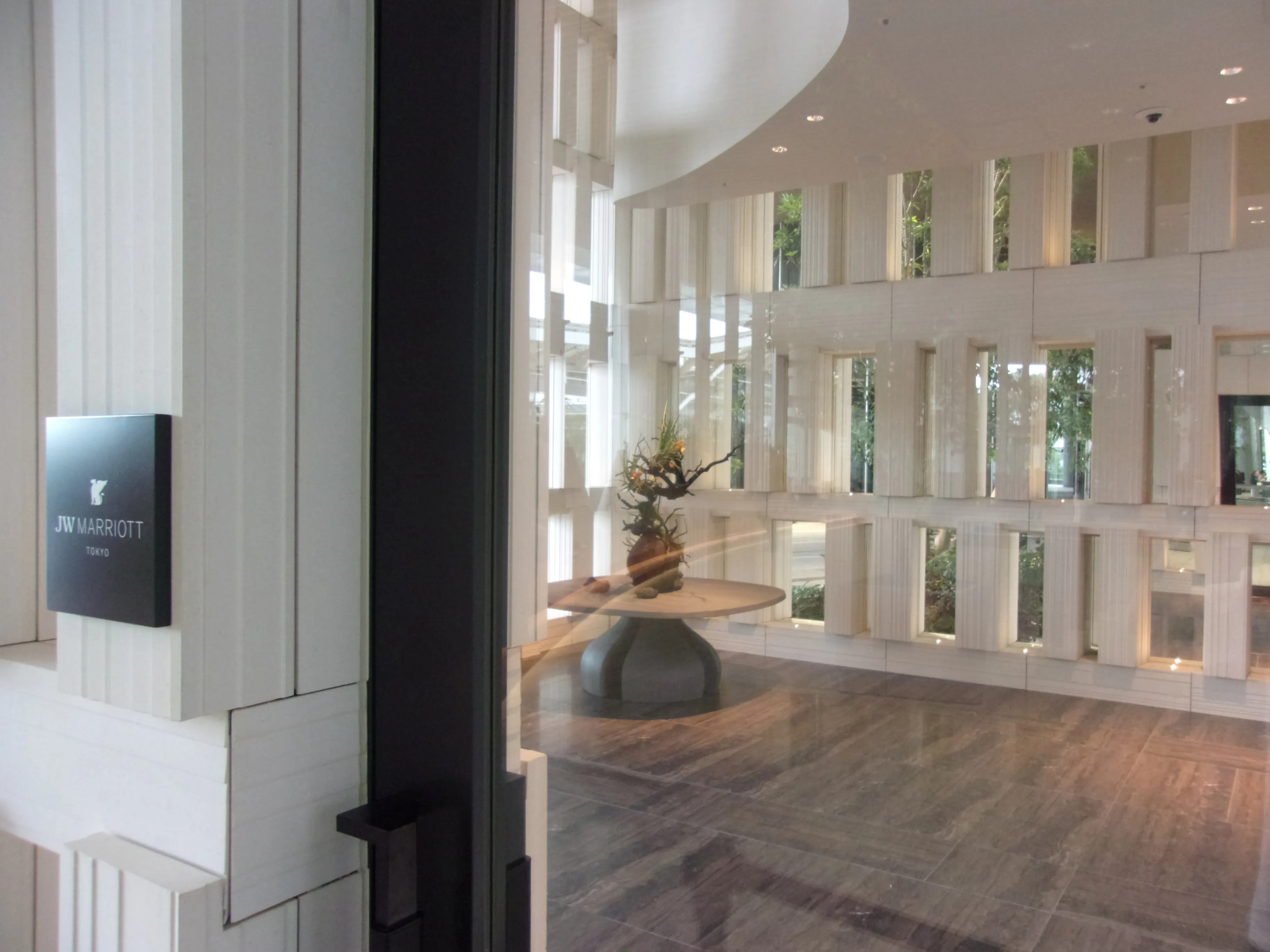 JW MARRIOTT TOKYOの名称サインと白い格子状の内装が見えるJWマリオット・ホテル東京のエントランス