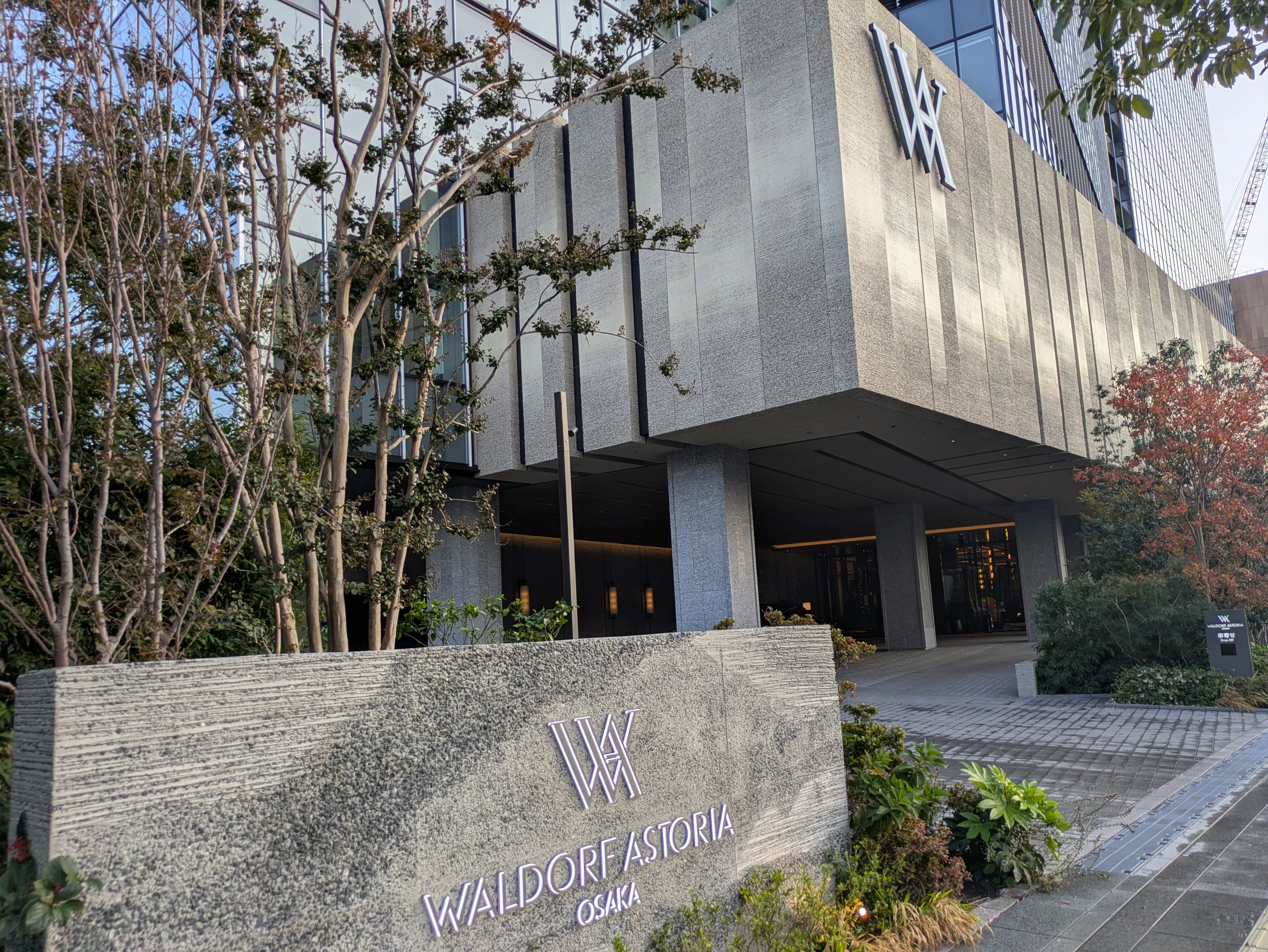 Waldorf Astoria Osakaの名称サインと玄関が写るウォルドーフ・アストリア大阪の外観
